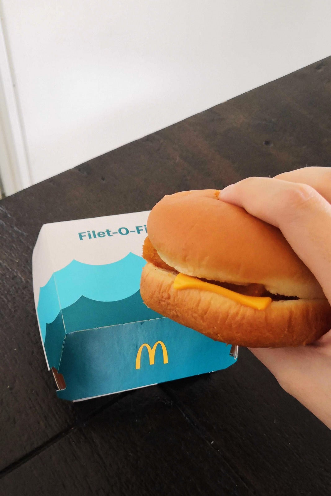 NOODOU holding a Filet O Fish burger in hand and a packaging box malaysia