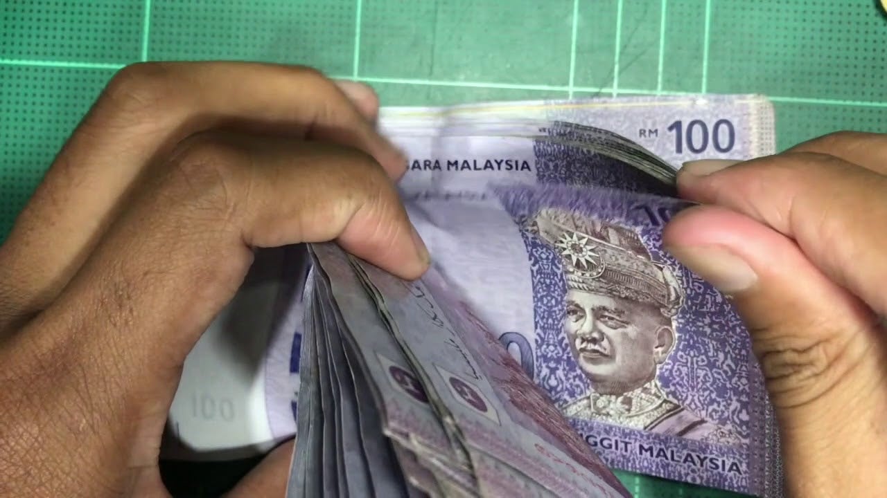 counting Malaysia Ringgit cash of RM100