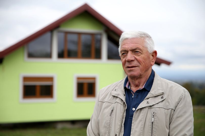 Vojin Kusic poses for photo in front of his rotating house in Srbac