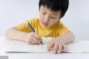 小学生小男孩写考卷做作业做功课