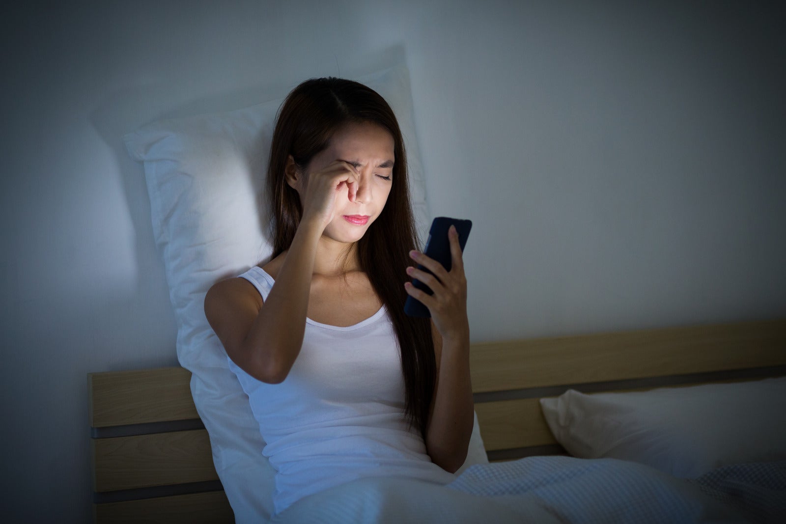 woman using phone on bed