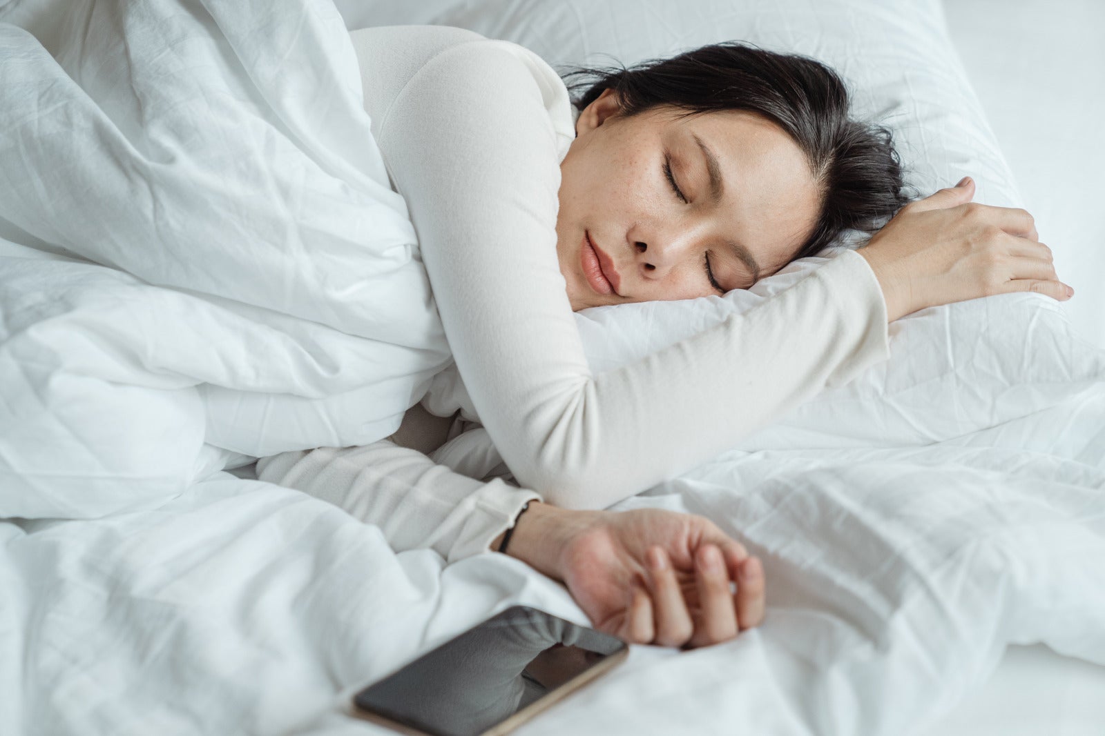 Asian Woman Resting In Bed Sleeping Phone At Side