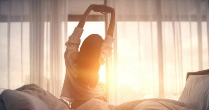 girl waking up bed sunrise happy