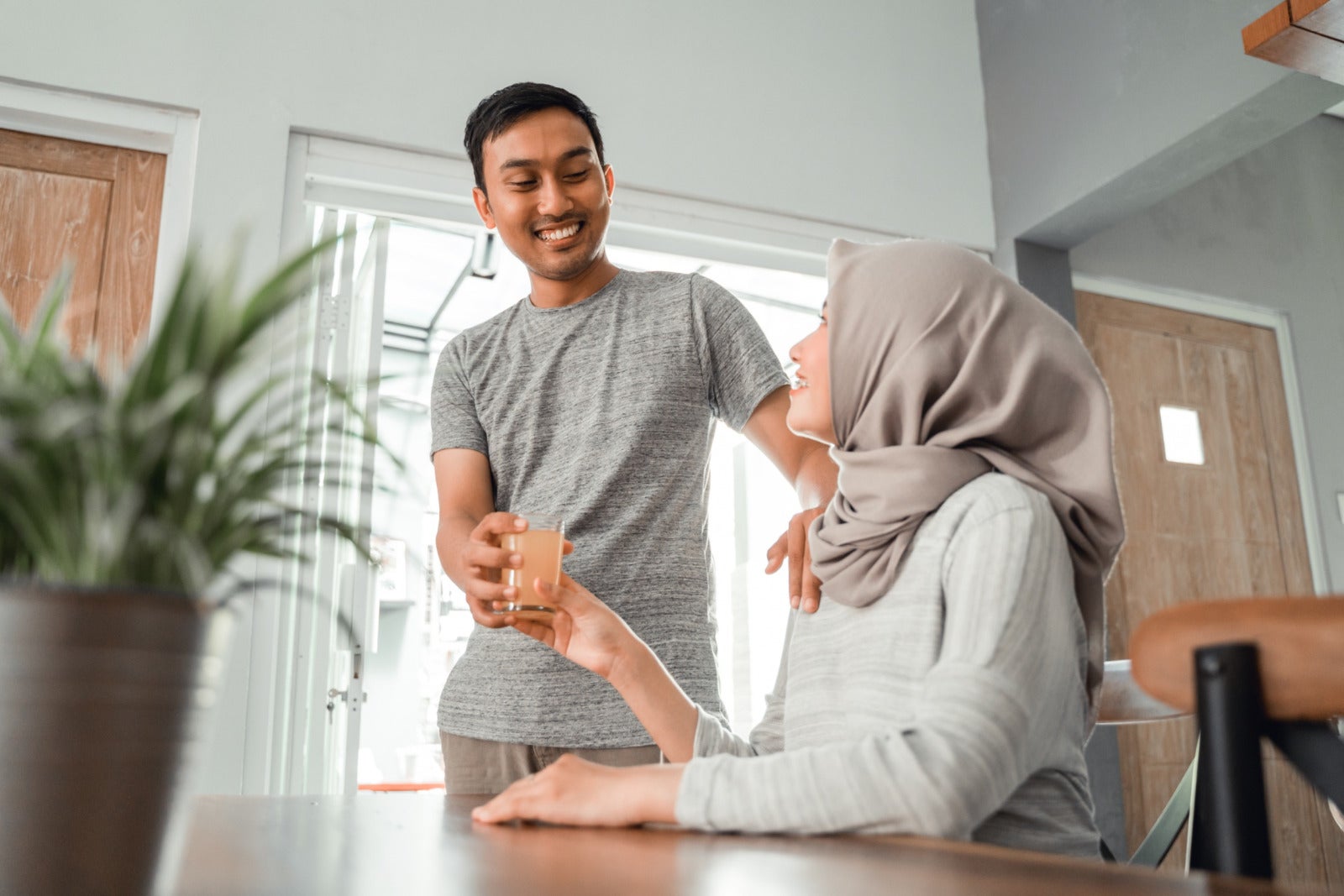 muslim couple man handing glass water to woman