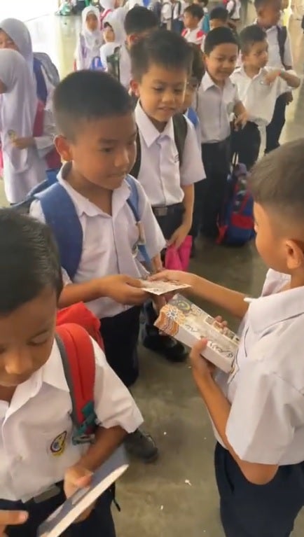 SS 1 kid give duit raya to classmate in school