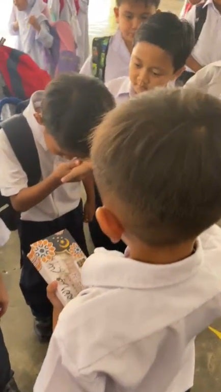 SS 2 kid give duit raya to classmate in school
