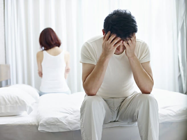 couple argue sitting on bed