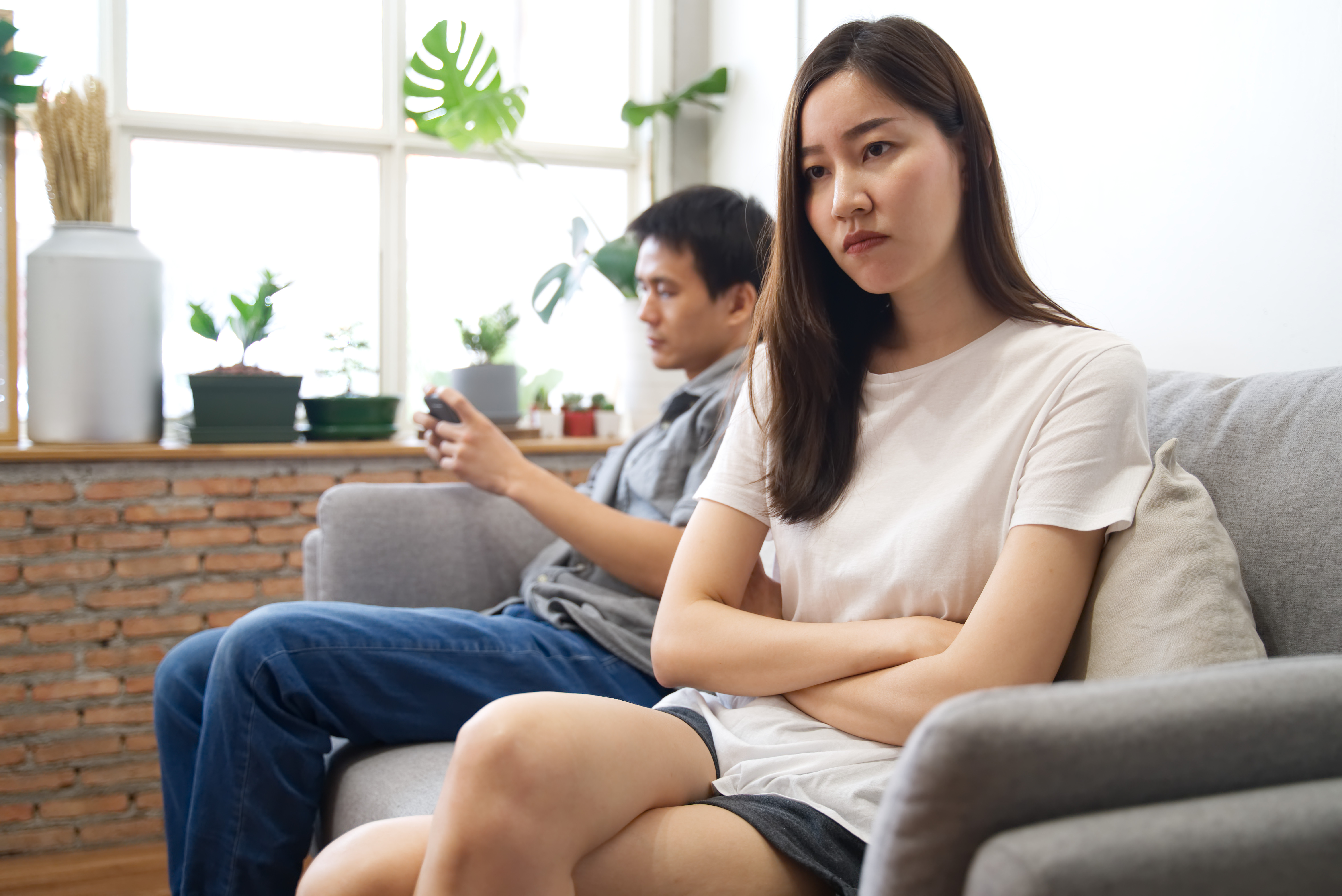 123rf couple angry sit on couch playing phone
