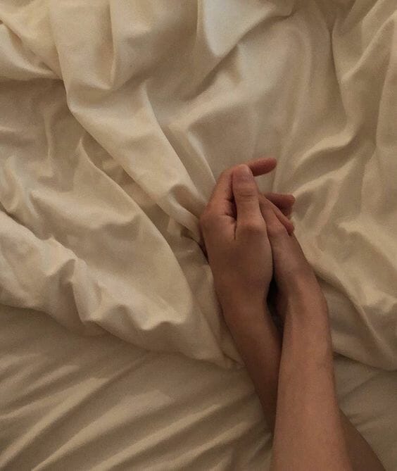hold hands on bed couple