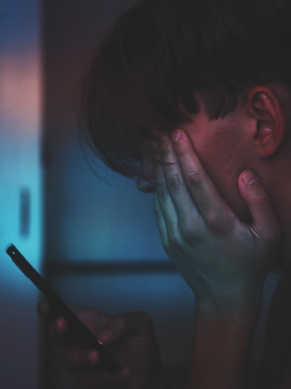 adrian swancar unsplash man holding phone indoor face closeup