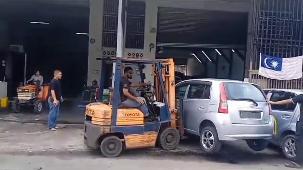 man use forklift to move car parked in front of car repair shop batu caves 4