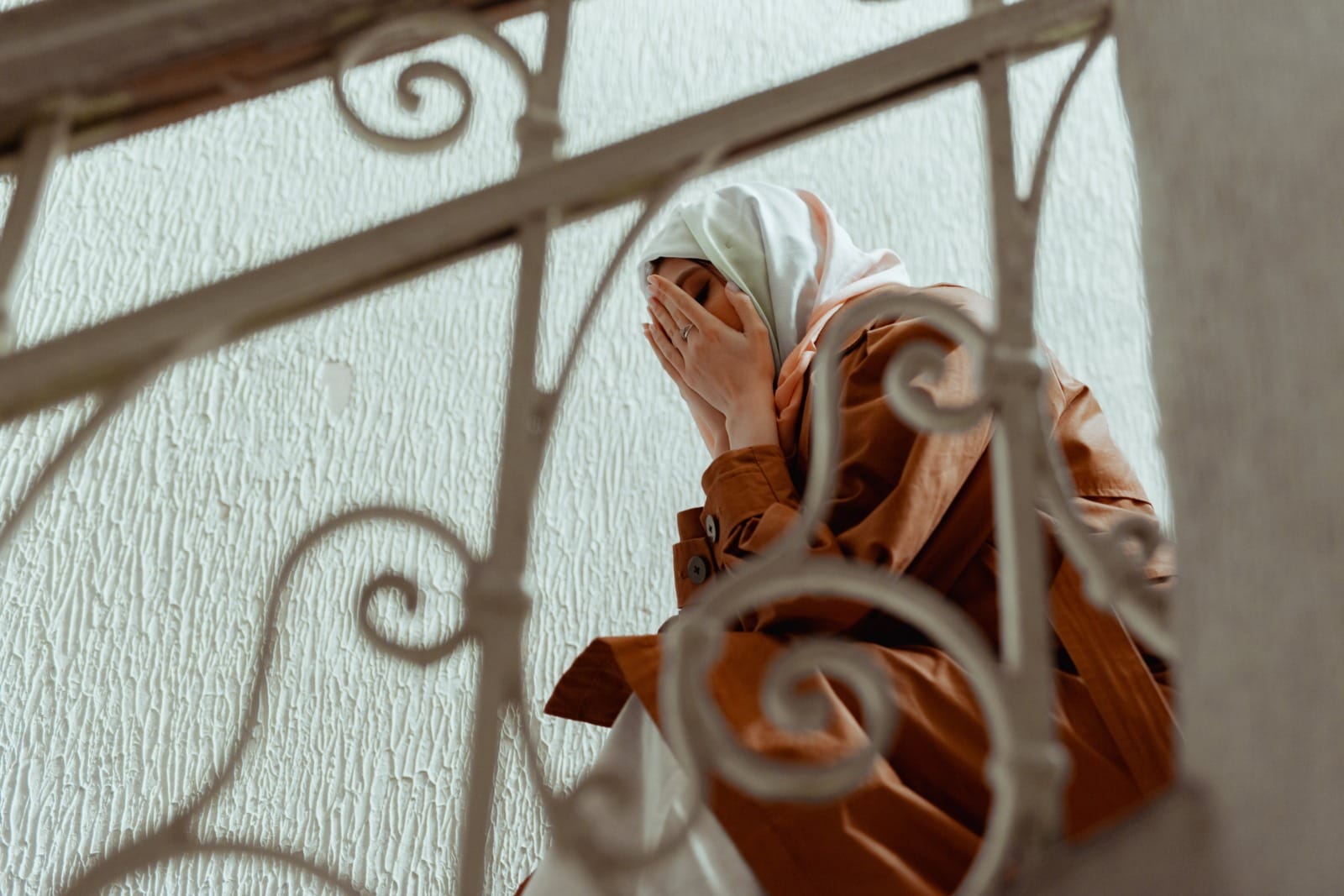 pexels mikhail nilov woman wearing hijab sitting at staircase saad cry cover face