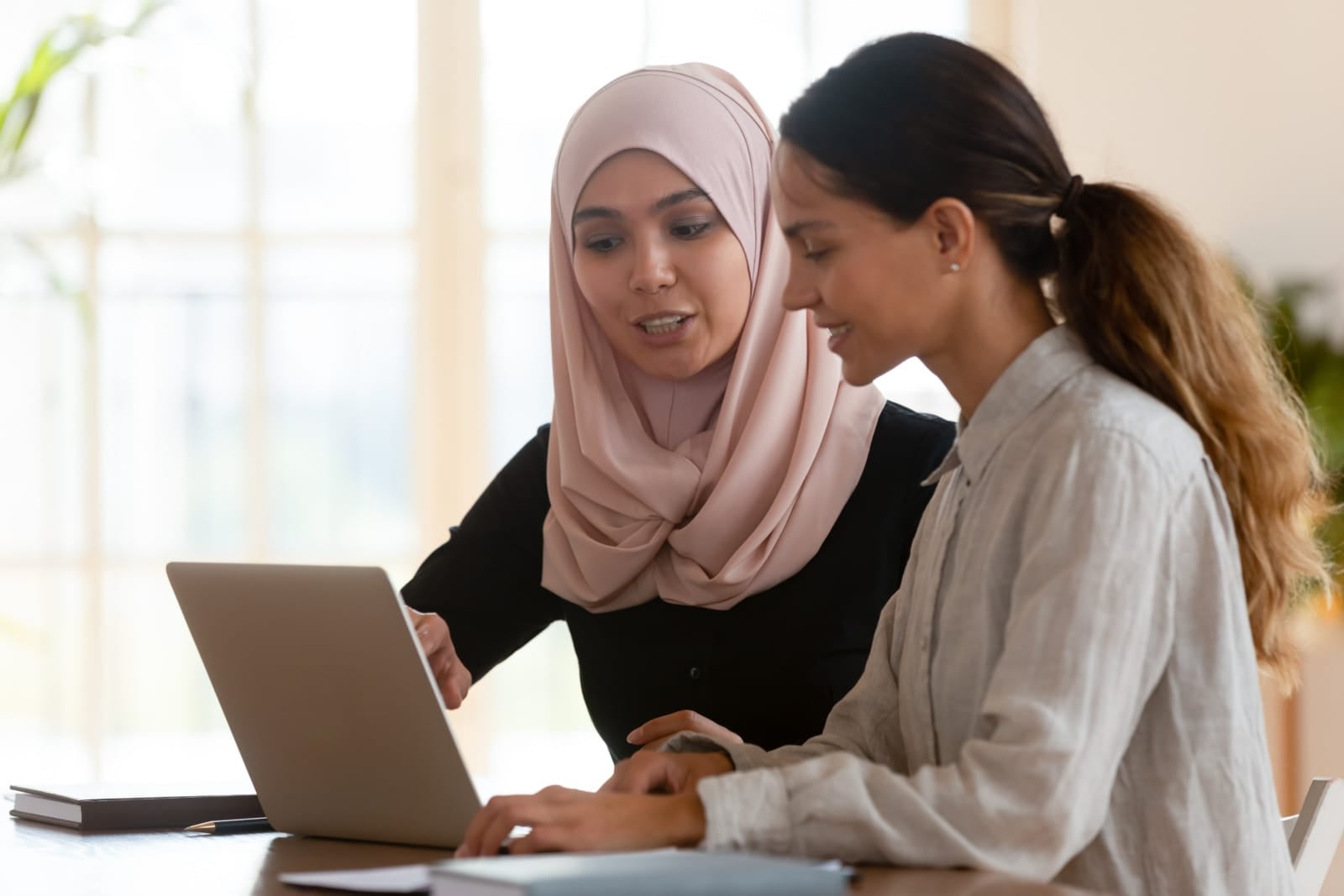 colleagues discussing work laptop 2 hijab muslim women 123rf