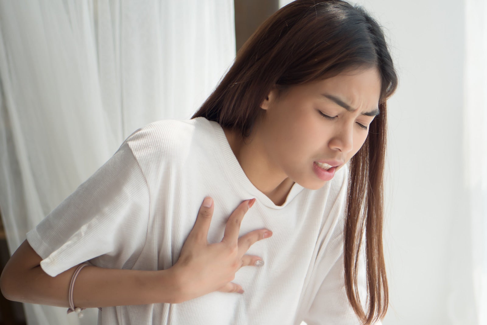 woman chest pain hard breath hand hold sick 123rf