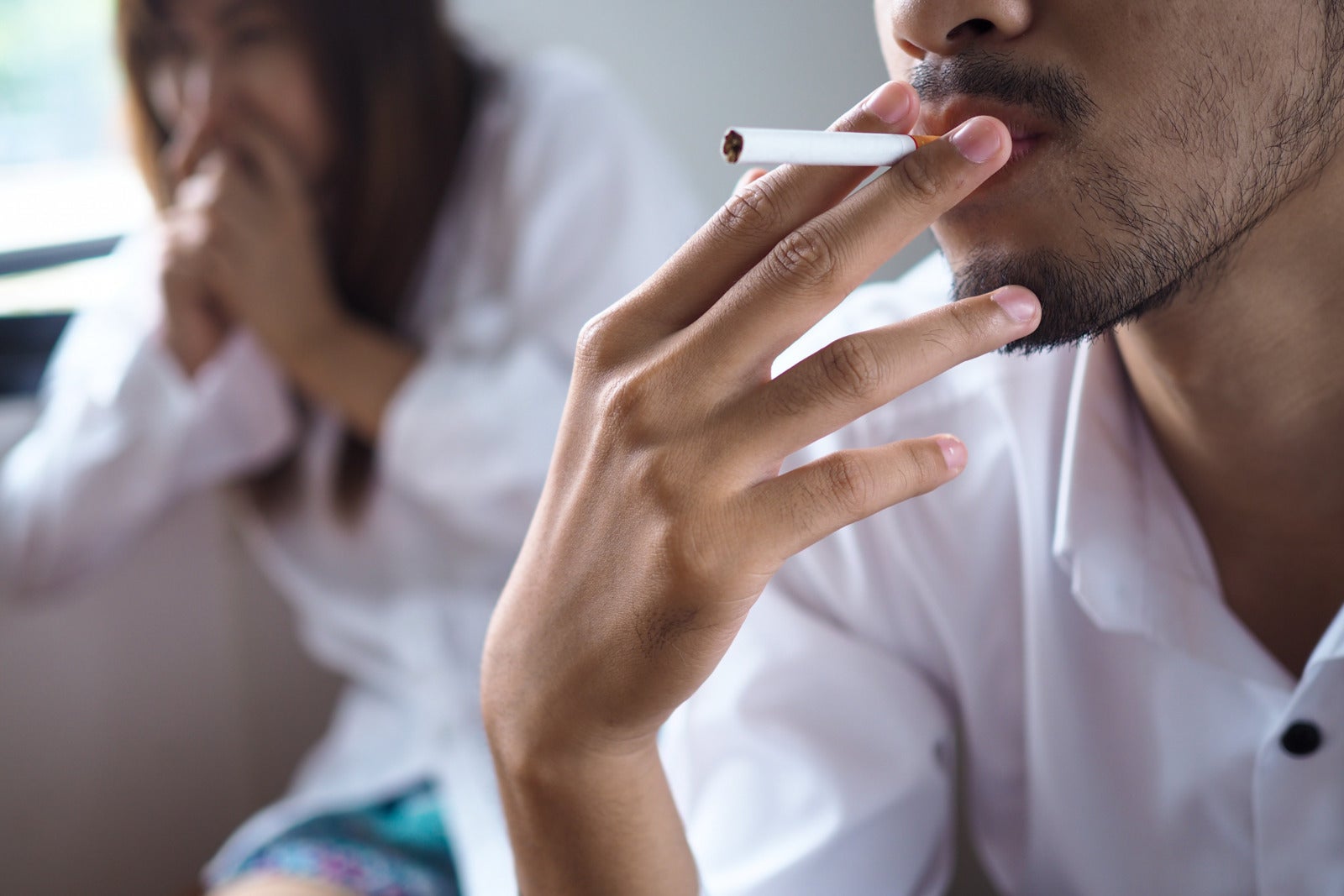 Man Smoking Indoors Woman Disgusted Cover Nose 123Rf