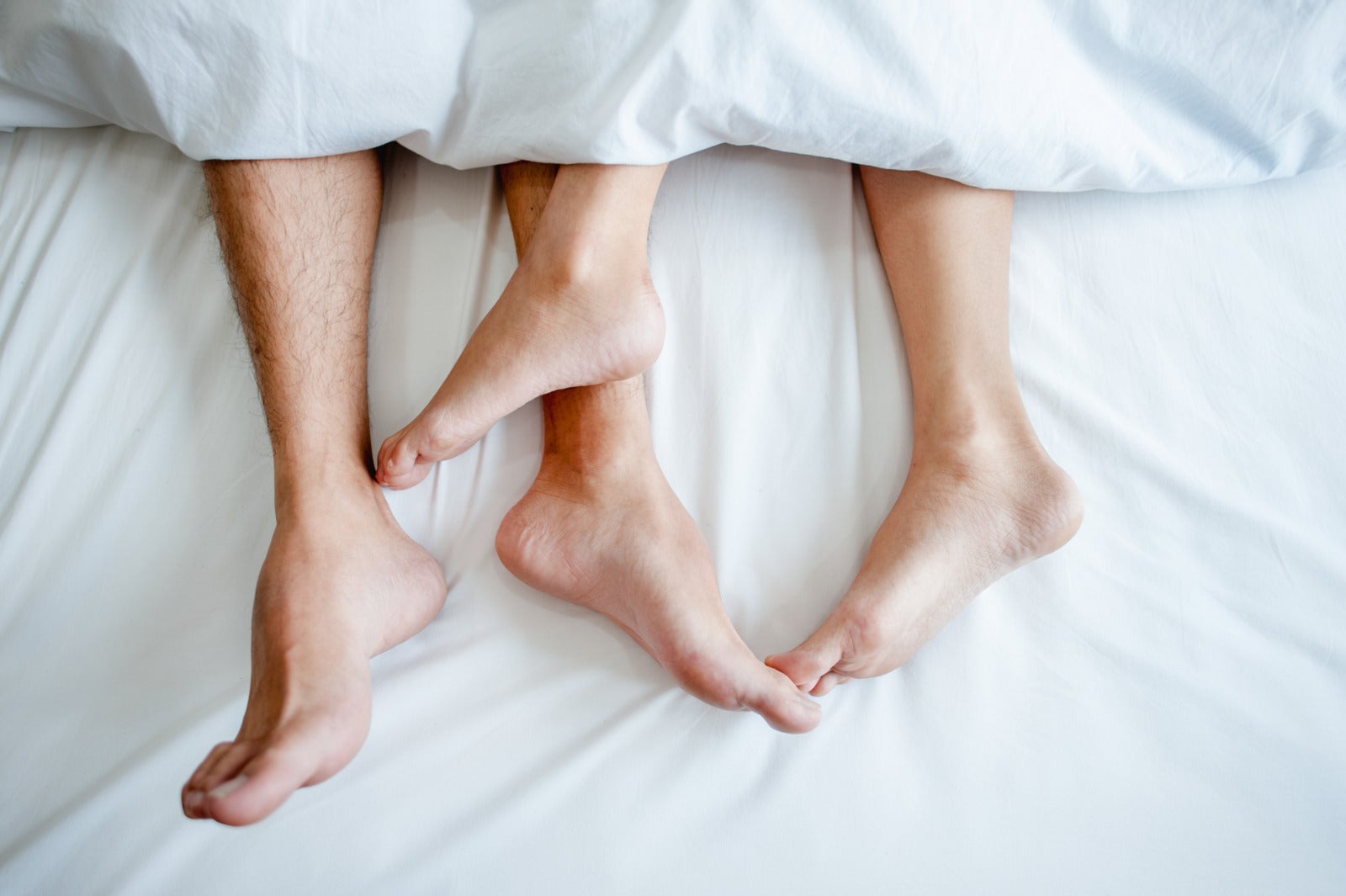 Couple Lying In Bed Leg Close Up White Blanket 123Rf