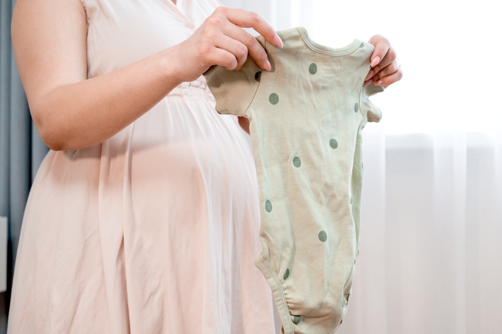 Pregnant Woman Holding Baby Clothes Side View 123Rf