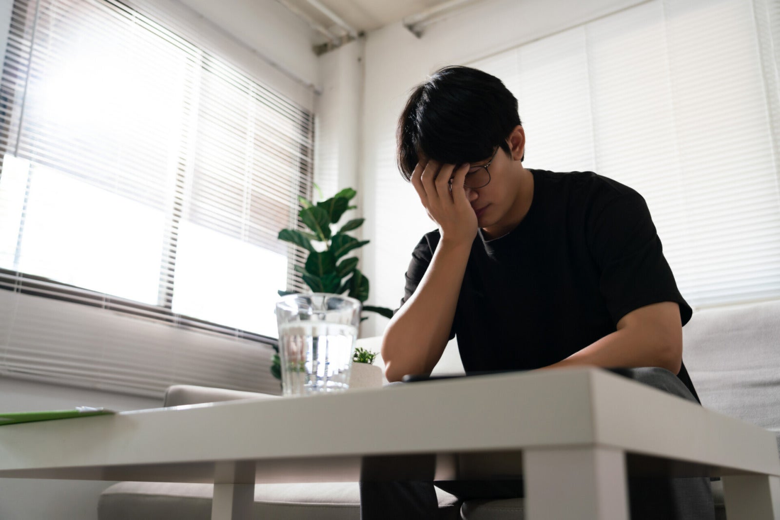 asian man covering face stressed depressed home 123rf