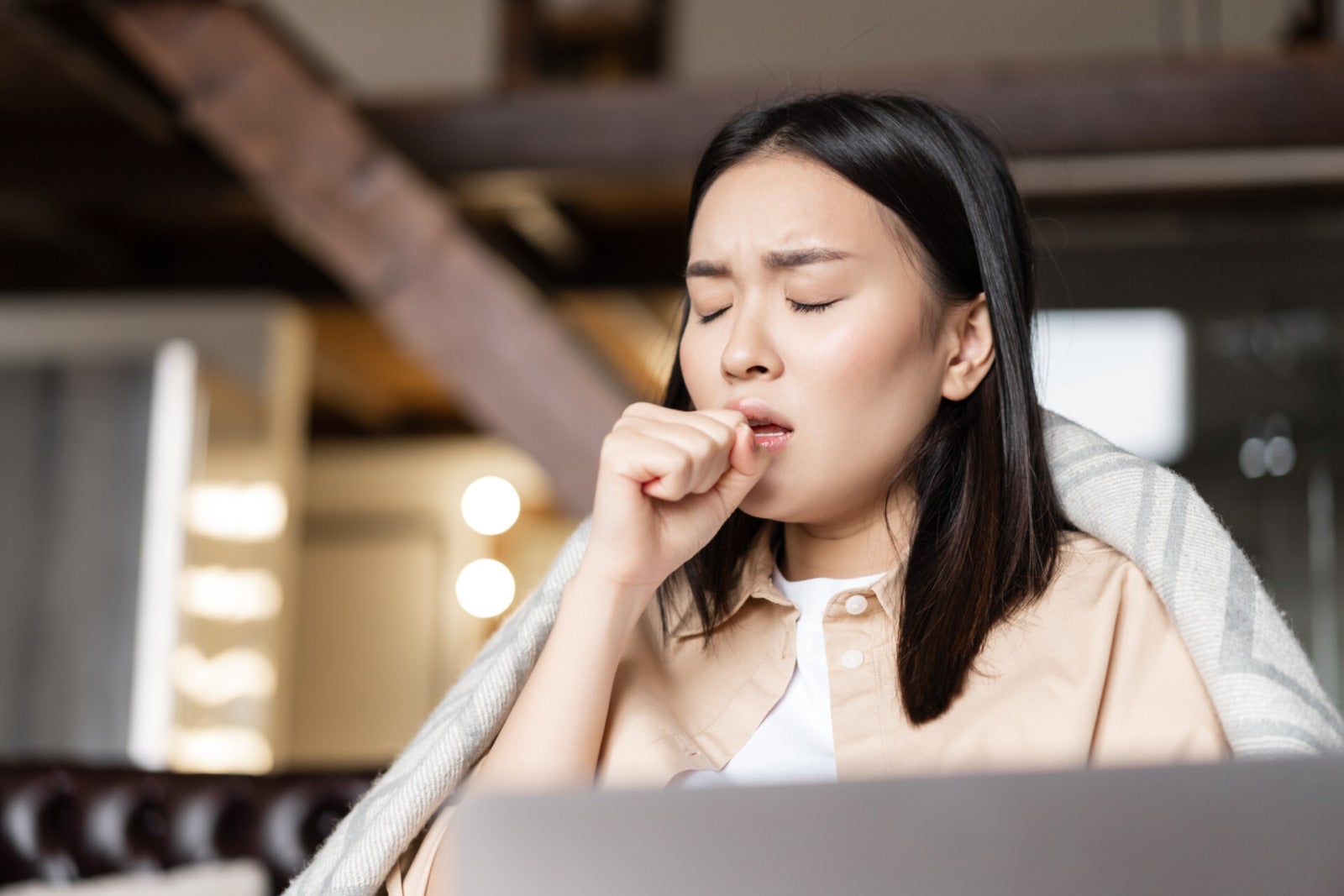 asian woman being ill coughing fist feeling sick home resting with laptop