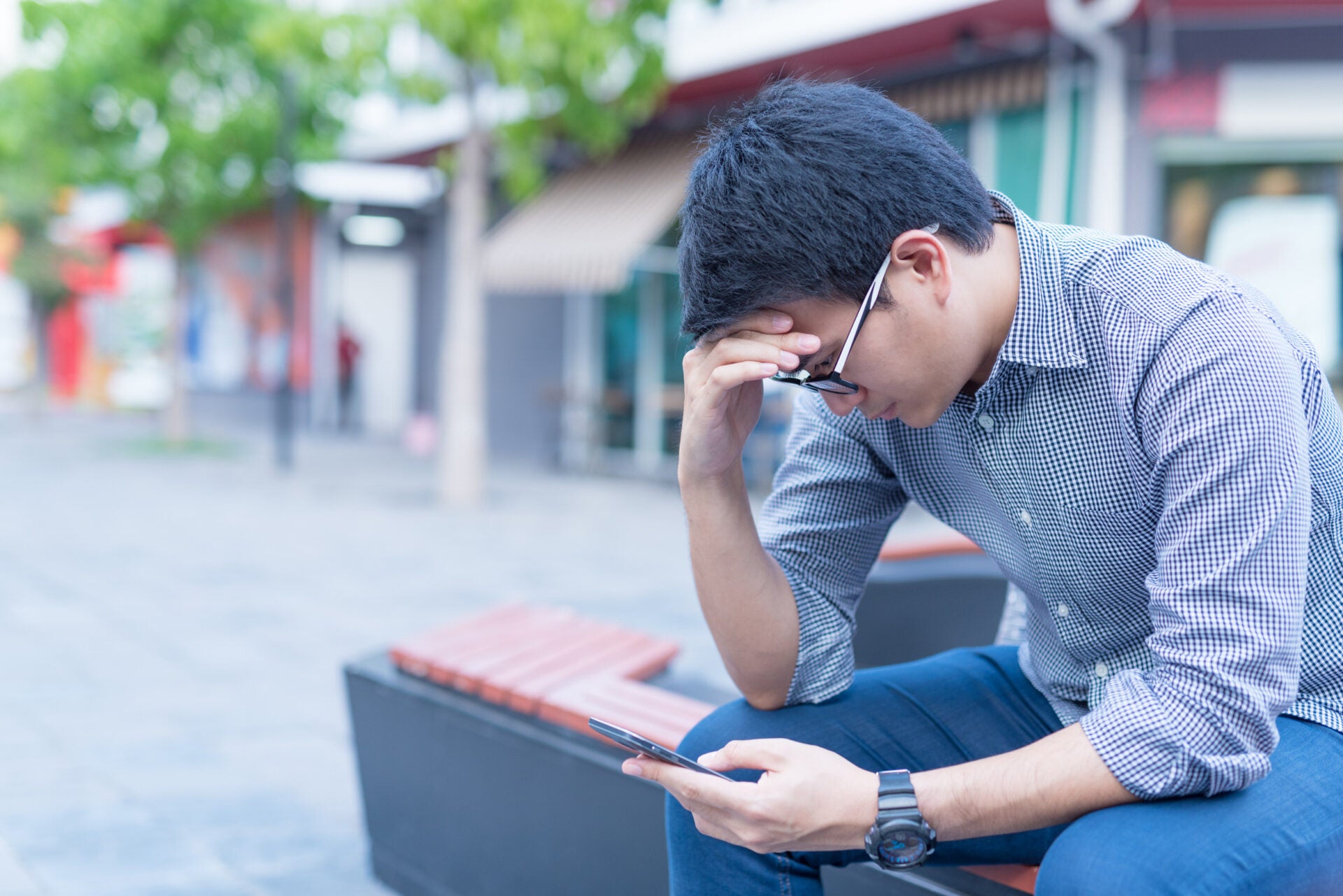 man holding phone headache sad 123rf