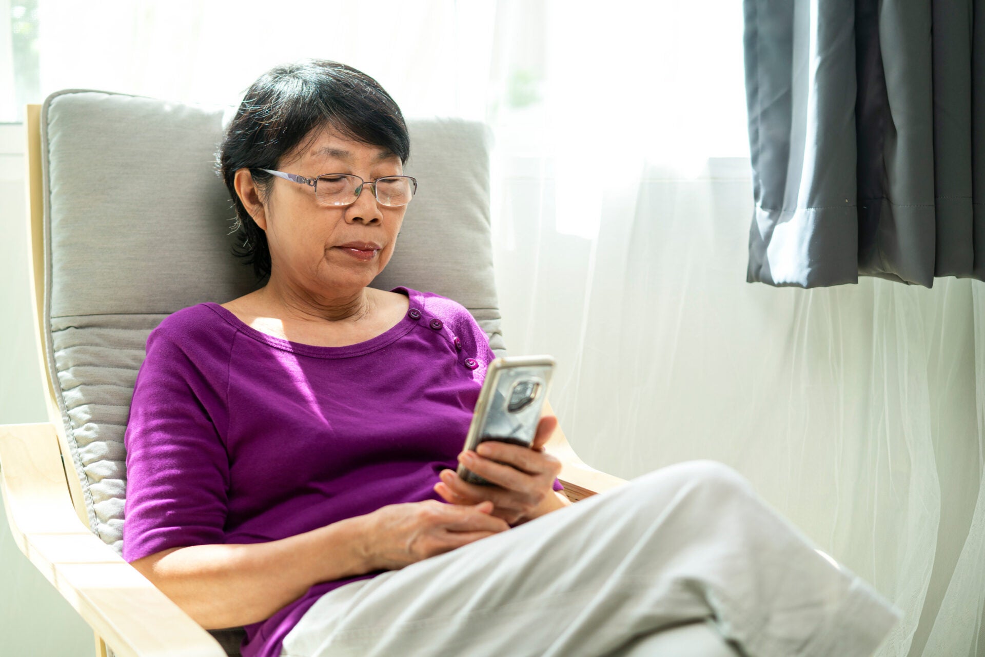 senior woman home sofa looking phone 123rf