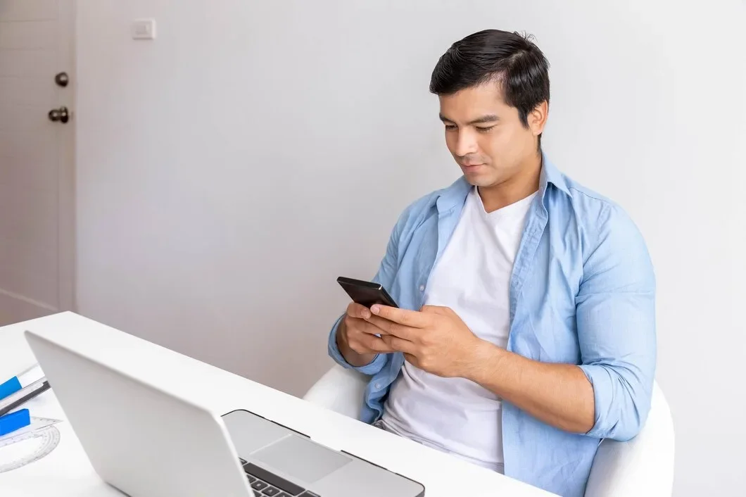 Attractive Man Is Working Home With Computer Notebook Using Mobile Phone 554837 251