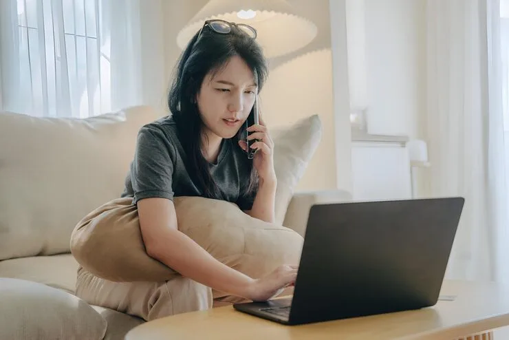 Woman Talking Cell Phone While Using Laptop 1218436 306
