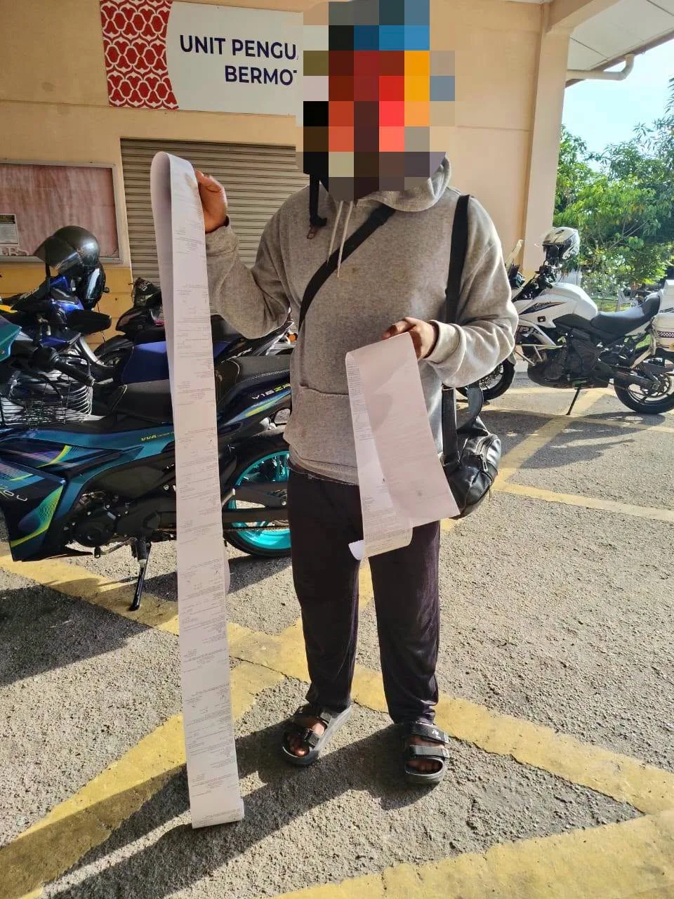 外籍摩托骑士违法被开罚单长到地上