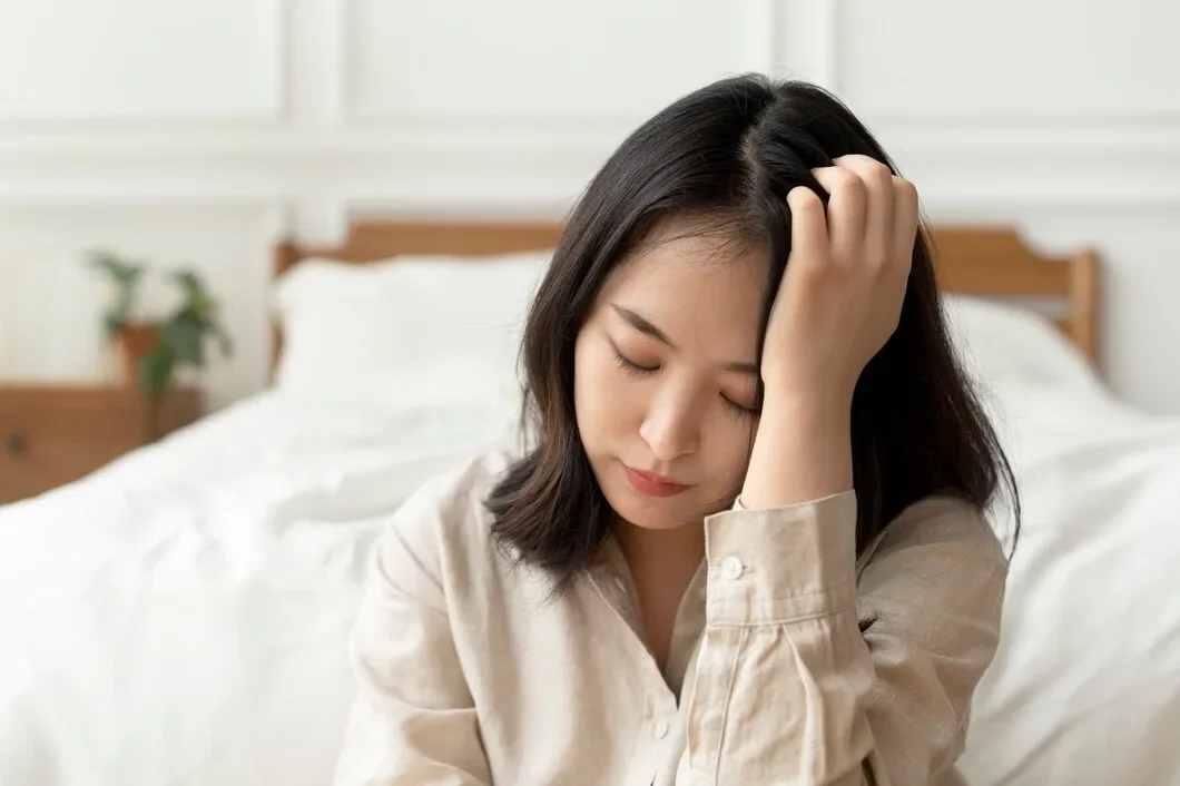 Asian Woman Sitting Sad By Her Bed 53876 127305