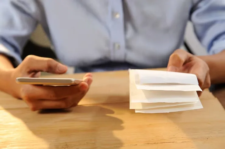 Closeup Of Person Calculating Or Paying Bills Receipts